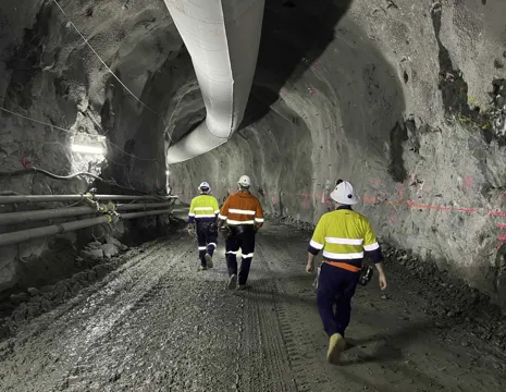 Genex Kidston Pumped Storage Hydro Project NAIF Site Visit With Three Workers Wearing High Vis Walking Down An Tunnel And Pipes