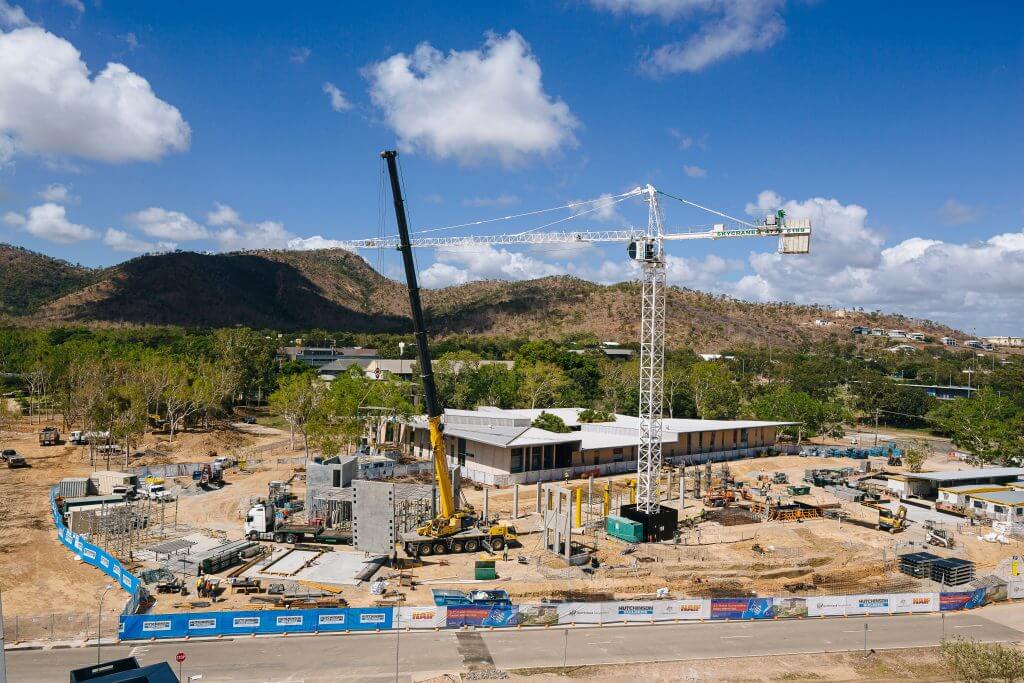 Aerial view of construction site for JCU Engineering and Innovation Place with crane and bunting in foreground and mountains in background